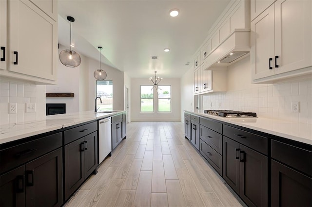 8101 Jenny Ln, Edmond, OK 73034 - kitchen featuring appliances with stainless steel finishes, white cabinets, a chandelier, a sink, and decorative light fixtures