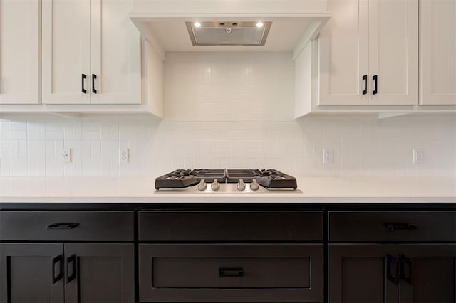 8101 Jenny Ln, Edmond, OK 73034 - kitchen with stainless steel gas stovetop, light countertops, white cabinets, and decorative backsplash