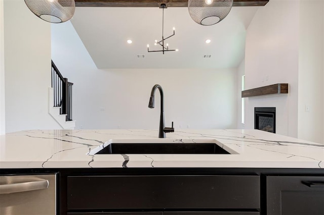 8101 Jenny Ln, Edmond, OK 73034 - kitchen with a sink, dishwasher, light stone counters, lofted ceiling, and a glass covered fireplace