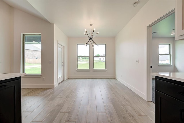 8101 Jenny Ln, Edmond, OK 73034 - unfurnished dining area with a chandelier, light wood-style flooring, and plenty of natural light