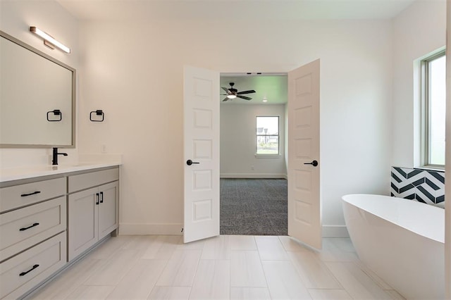 8101 Jenny Ln, Edmond, OK 73034 - full bathroom featuring baseboards, a freestanding bath, vanity, and a ceiling fan