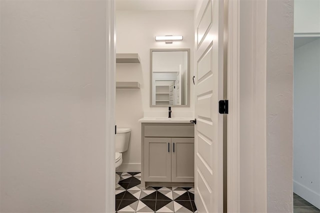 8101 Jenny Ln, Edmond, OK 73034 - half bathroom featuring toilet, vanity, baseboards, and tile patterned floors