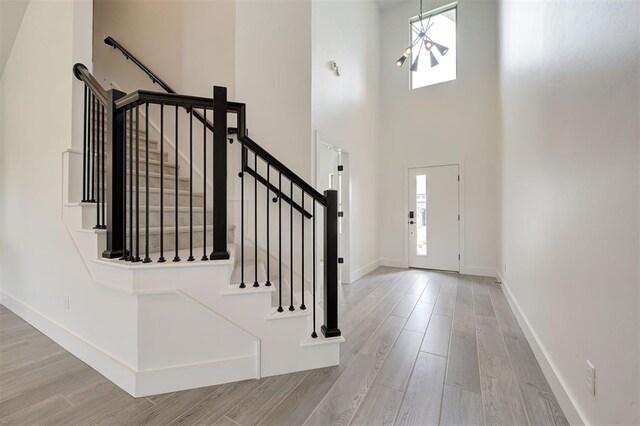 8101 Jenny Ln, Edmond, OK 73034 - entryway with plenty of natural light, wood finished floors, stairway, baseboards, and a towering ceiling