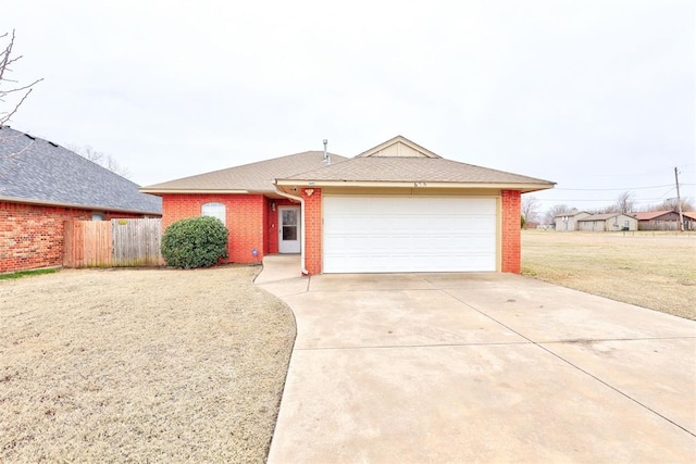 single story home with brick siding, a front lawn, fence, concrete driveway, and an attached garage