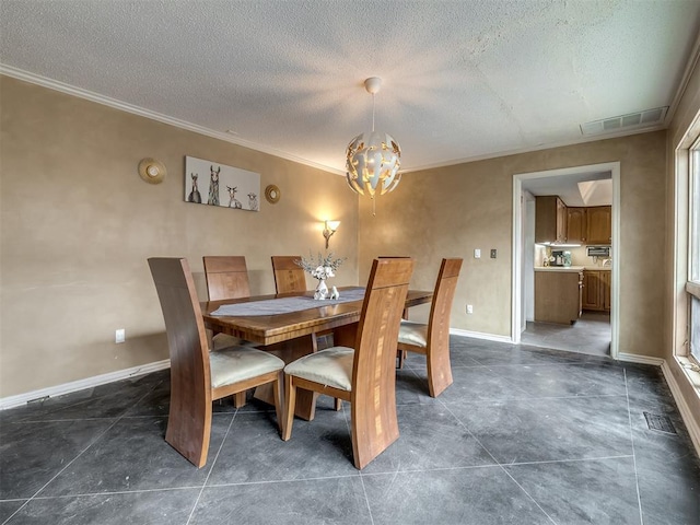 dining space featuring visible vents, ornamental molding, a textured ceiling, baseboards, and a chandelier