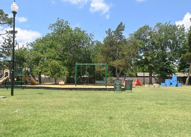 communal playground with a yard and fence