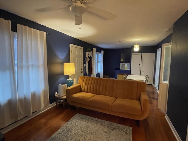 living area with ceiling fan, baseboards, and wood finished floors