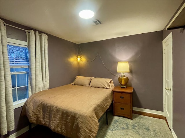 bedroom featuring baseboards and visible vents