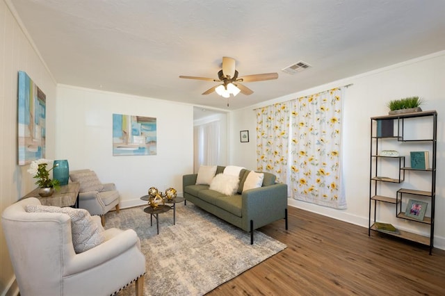 living room with visible vents, a ceiling fan, wood finished floors, and crown molding