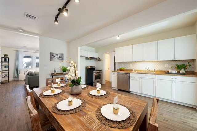 dining area with visible vents and light wood-style floors