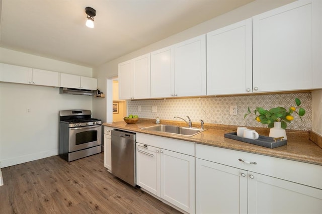 kitchen with a sink, tasteful backsplash, wood finished floors, stainless steel appliances, and white cabinets