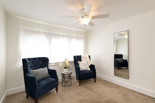 sitting room featuring baseboards, carpet floors, and a ceiling fan