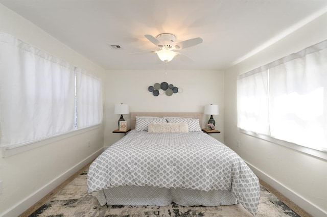 bedroom with baseboards, visible vents, and ceiling fan