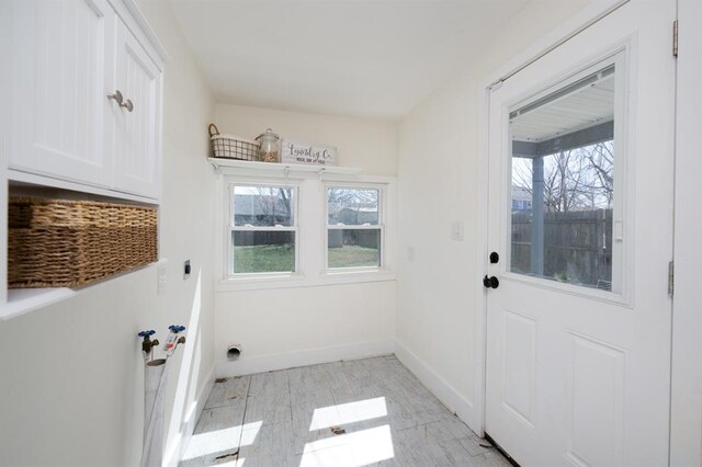 doorway to outside featuring a healthy amount of sunlight and baseboards