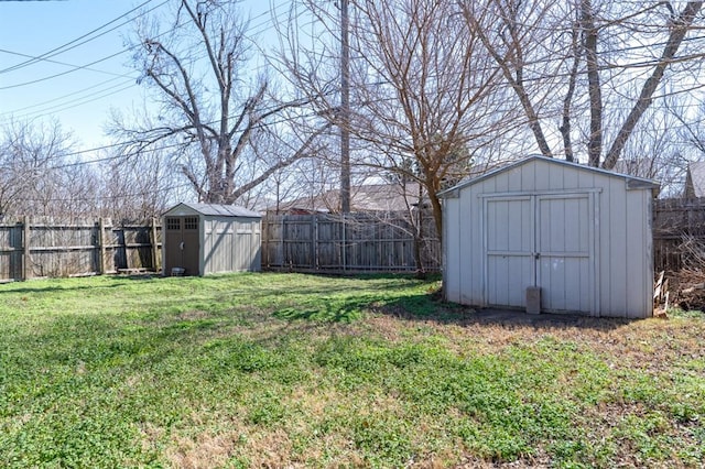 view of yard with an outbuilding, a fenced backyard, and a shed