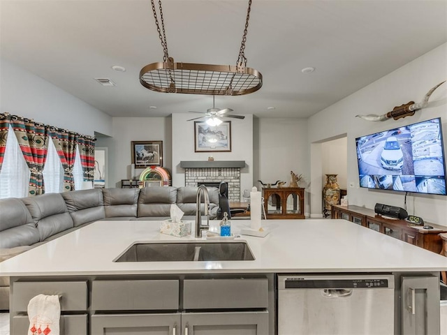 kitchen featuring a sink, stainless steel dishwasher, open floor plan, light countertops, and ceiling fan