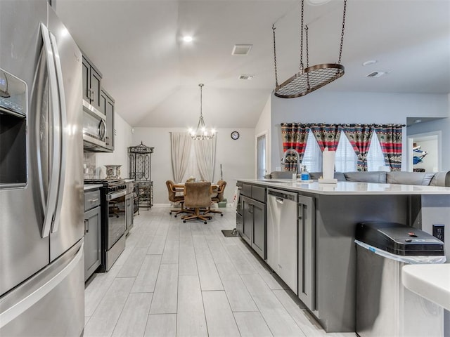 kitchen featuring visible vents, a sink, vaulted ceiling, appliances with stainless steel finishes, and a chandelier