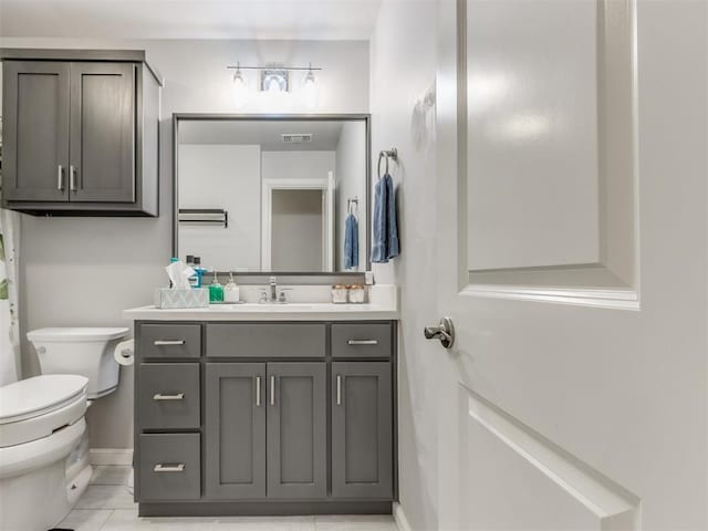 bathroom with vanity, toilet, baseboards, and visible vents