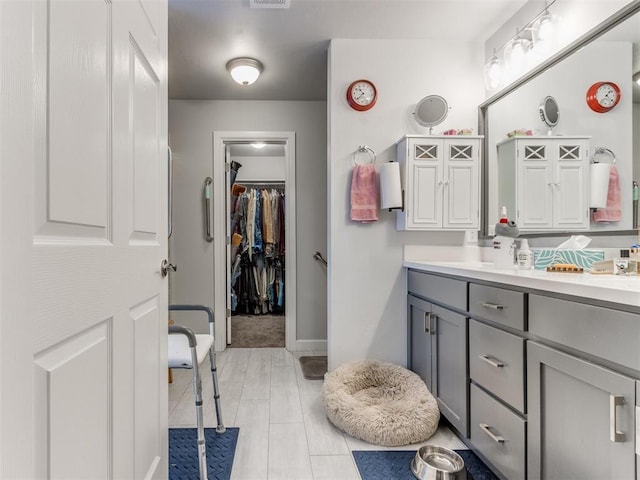 full bathroom featuring a spacious closet, visible vents, and double vanity