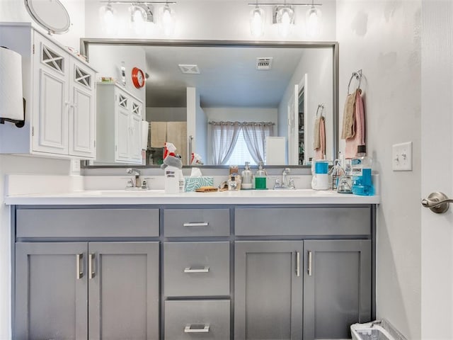 full bath featuring double vanity, visible vents, and a sink