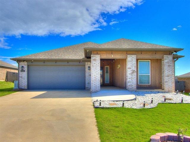 294 Emmy Jean Dr, Blanchard, OK 73010 - view of front facade featuring a front lawn, concrete driveway, brick siding, roof with shingles, and a garage