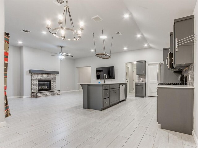 294 Emmy Jean Dr, Blanchard, OK 73010 - kitchen with light countertops, stainless steel dishwasher, gray cabinetry, open floor plan, and ceiling fan with notable chandelier