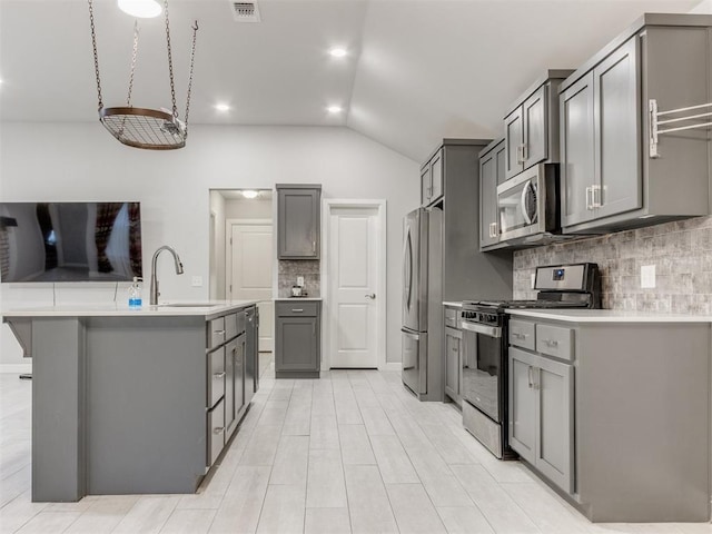 294 Emmy Jean Dr, Blanchard, OK 73010 - kitchen with vaulted ceiling, appliances with stainless steel finishes, gray cabinetry, and a sink
