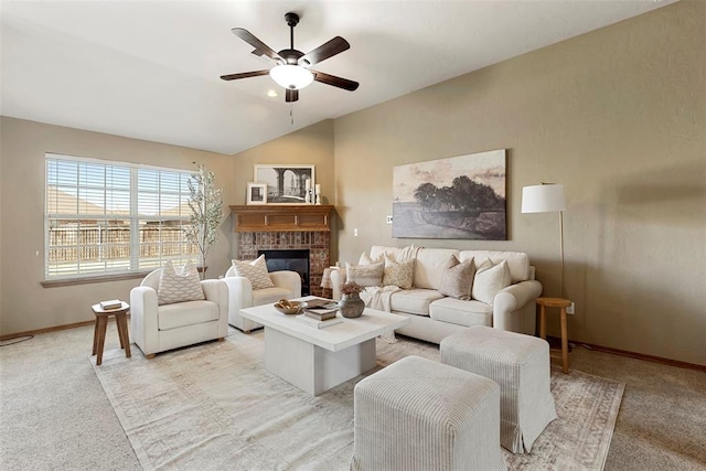 living room featuring baseboards, vaulted ceiling, light carpet, a fireplace, and a ceiling fan