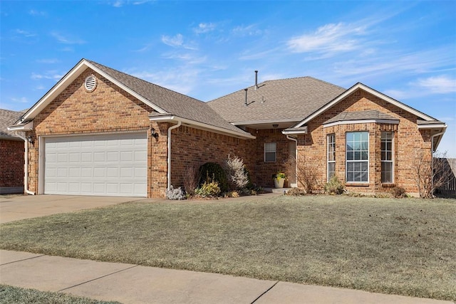 single story home with brick siding, an attached garage, concrete driveway, and a front lawn