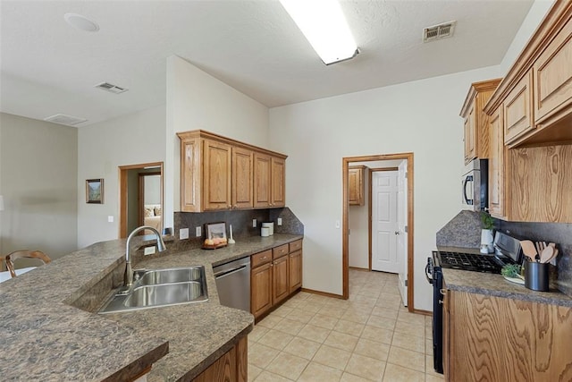 kitchen featuring a sink, visible vents, dark countertops, and appliances with stainless steel finishes