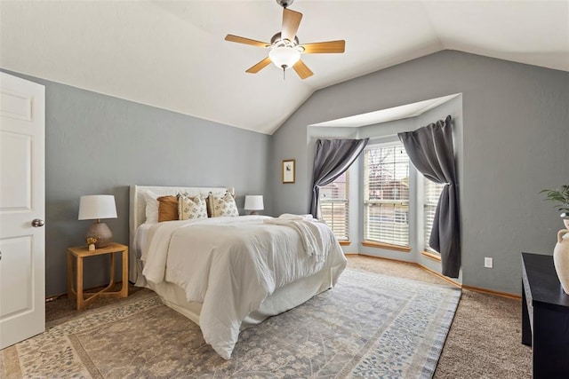 bedroom featuring ceiling fan, baseboards, lofted ceiling, carpet flooring, and a textured wall