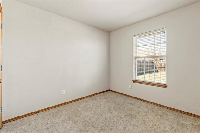 carpeted empty room with baseboards