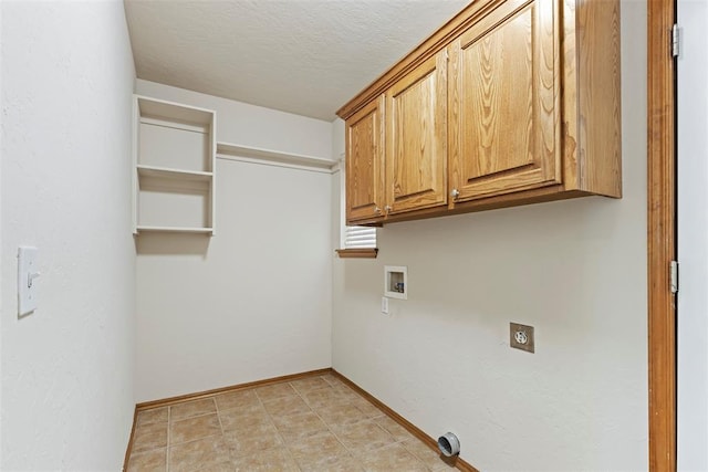 washroom featuring hookup for a washing machine, baseboards, cabinet space, electric dryer hookup, and a textured ceiling