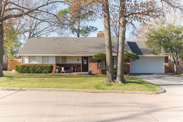 ranch-style home featuring a front yard, fence, brick siding, and driveway