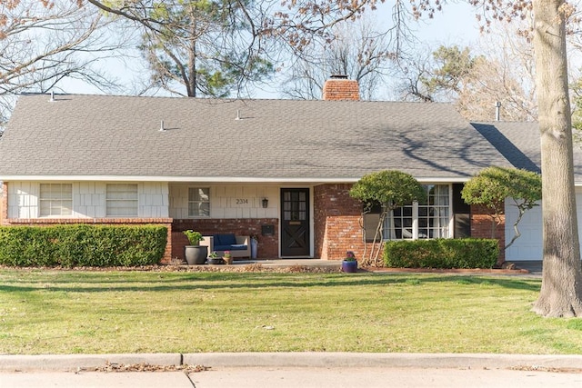 view of front facade featuring brick siding, an attached garage, a chimney, and a front yard