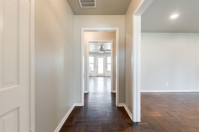 hall featuring visible vents and baseboards