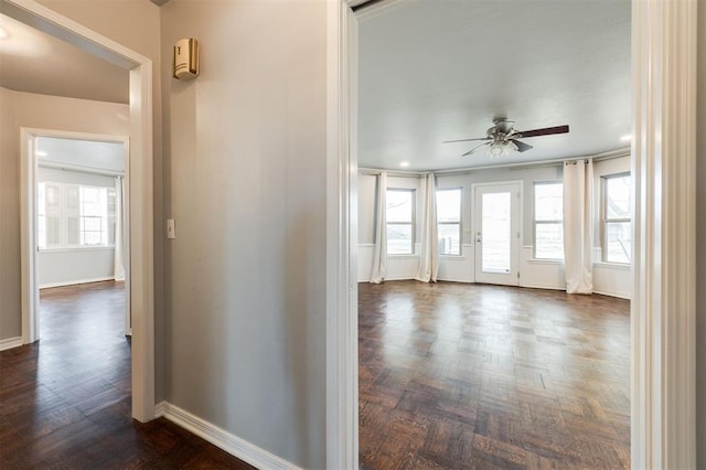 hall featuring plenty of natural light and baseboards