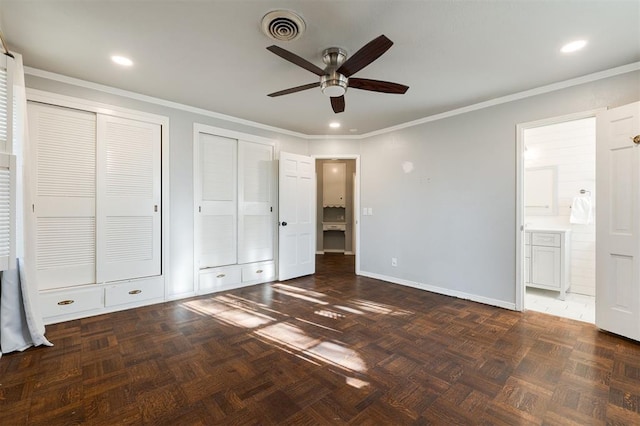 unfurnished bedroom featuring baseboards, visible vents, ensuite bath, ornamental molding, and two closets