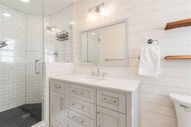 full bathroom featuring vanity, a shower stall, and toilet