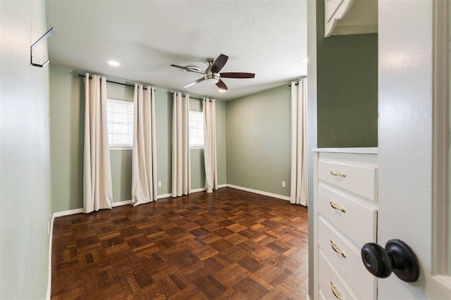 unfurnished room featuring baseboards, a textured ceiling, and a ceiling fan