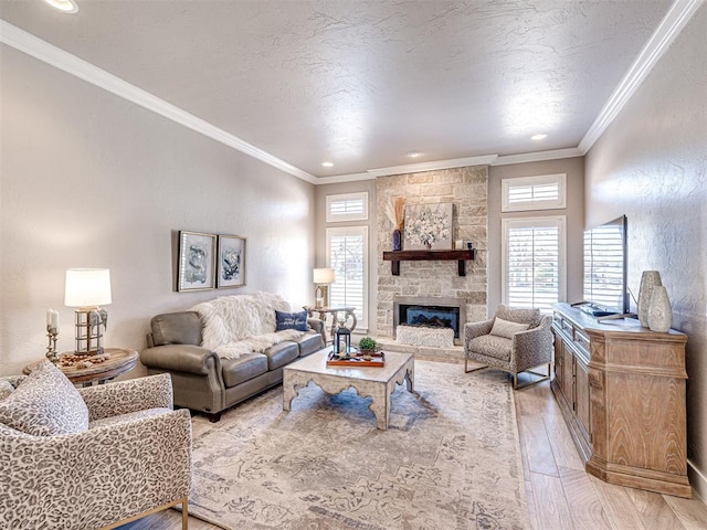 living area with light wood-style flooring, a fireplace, a textured ceiling, and crown molding