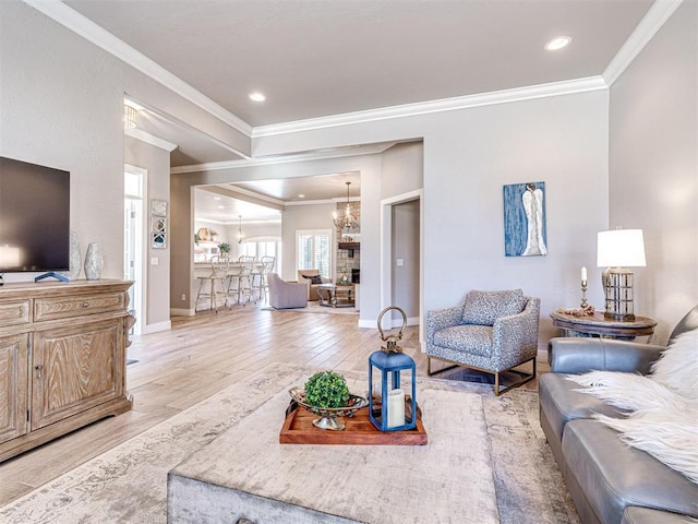 living area featuring baseboards, recessed lighting, light wood-style floors, crown molding, and a notable chandelier