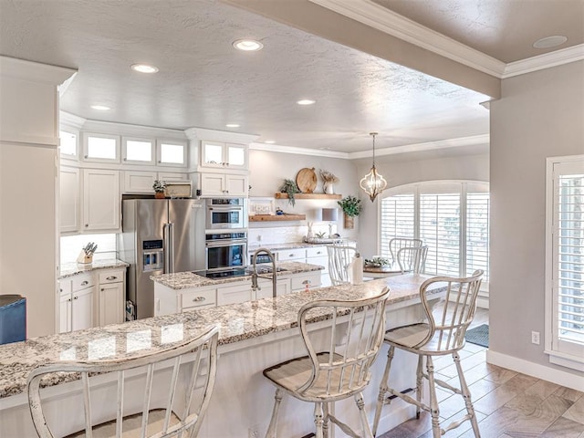 kitchen featuring a breakfast bar, ornamental molding, glass insert cabinets, appliances with stainless steel finishes, and white cabinetry