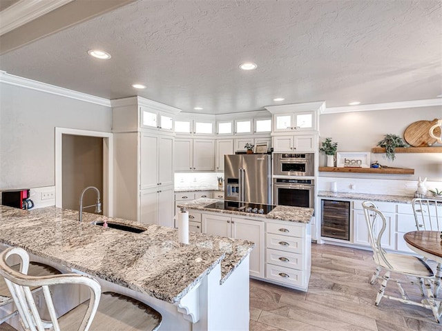 kitchen featuring a sink, wine cooler, appliances with stainless steel finishes, and white cabinetry