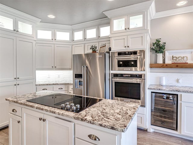 kitchen with backsplash, crown molding, beverage cooler, white cabinets, and stainless steel appliances