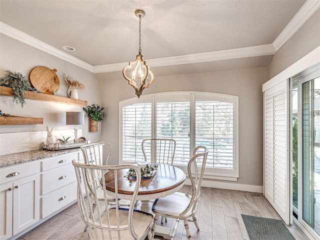 dining space with a notable chandelier, a healthy amount of sunlight, light wood-style flooring, and ornamental molding