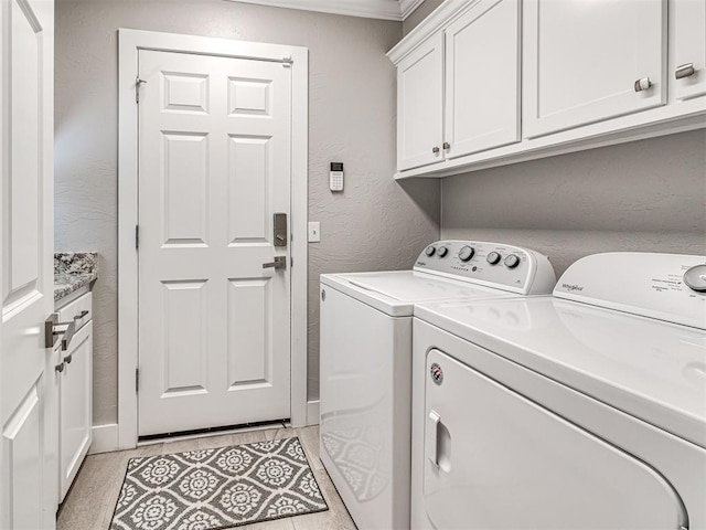 laundry area with cabinet space, separate washer and dryer, and a textured wall