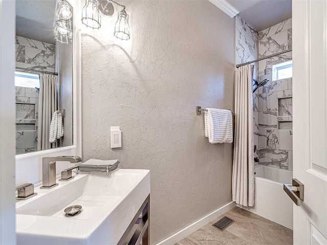 full bathroom with visible vents, a textured wall, shower / bath combo with shower curtain, and baseboards