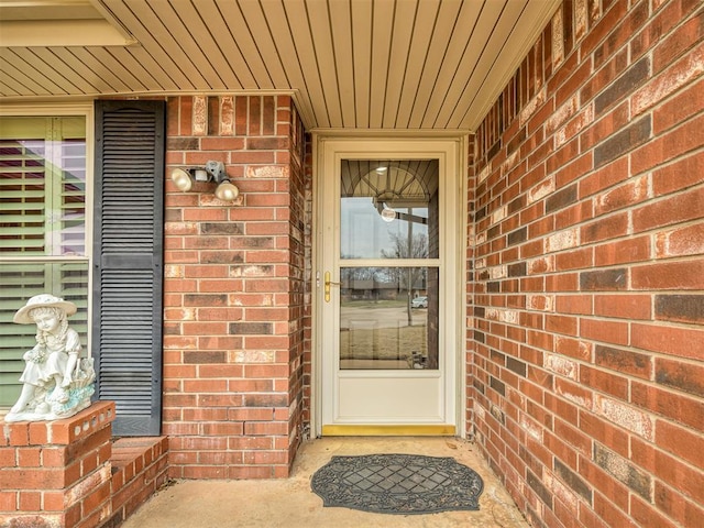 view of exterior entry featuring brick siding