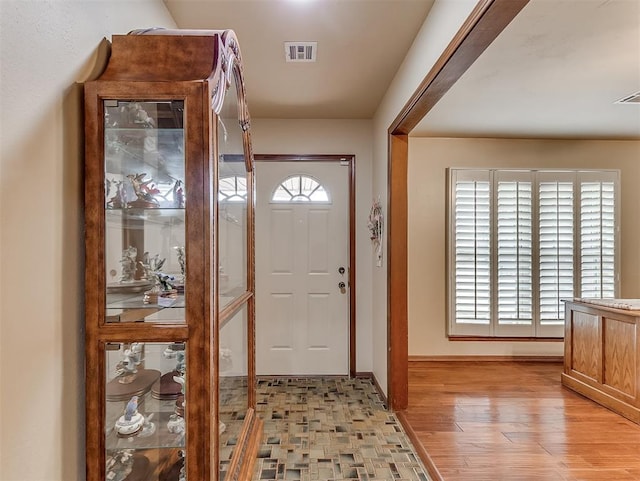 foyer featuring plenty of natural light, baseboards, visible vents, and light wood-type flooring